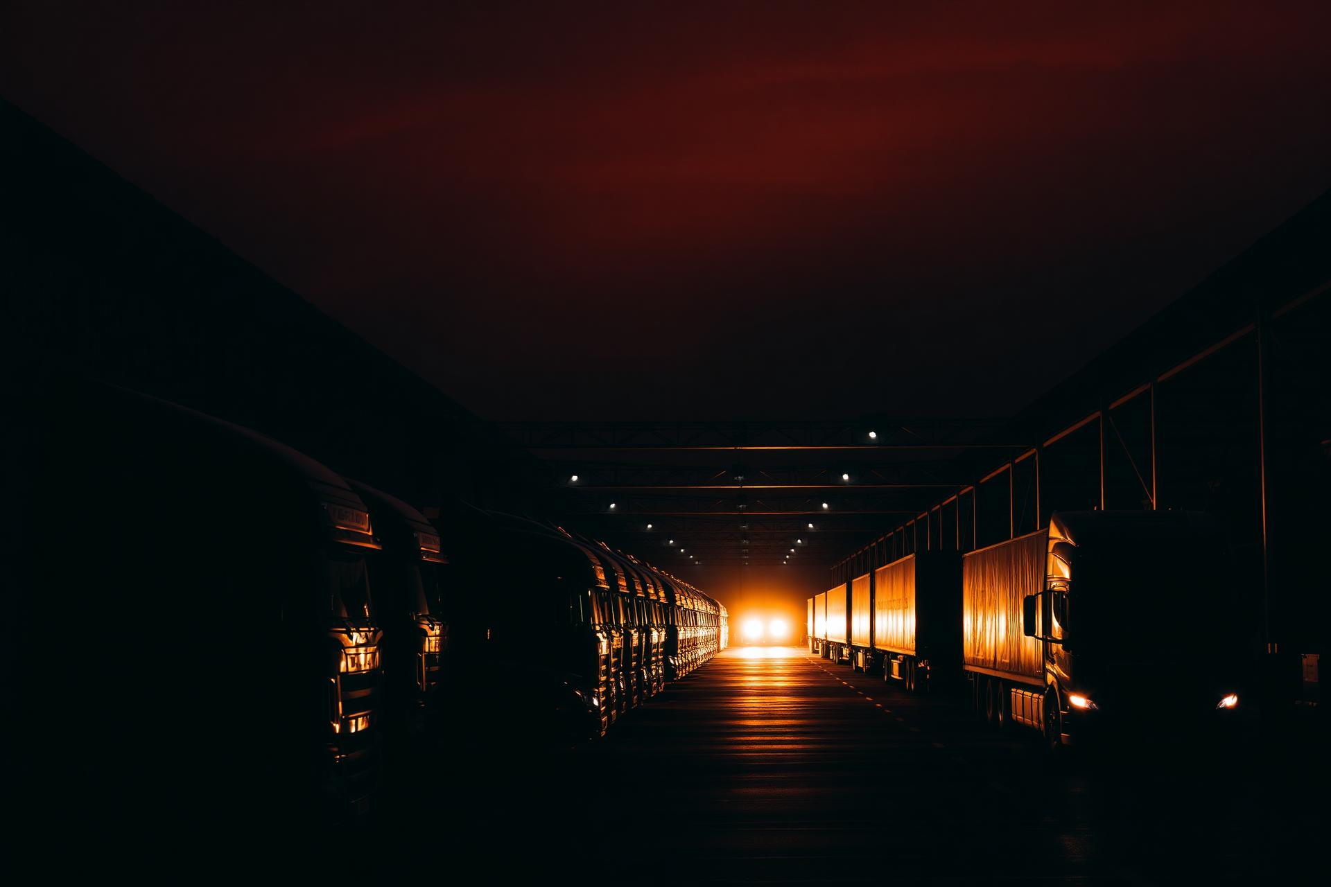 Fleet of semi-trucks at a logistics warehouse loading dock